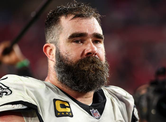 Jason Kelce wearing a football uniform with a captain's patch, looking serious during a game