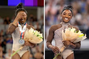 Simone Biles smiles while holding flowers and a medal, wearing a sequined gymnastics leotard