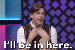 A person on a stage saying, &quot;I'll be in here,&quot; and hides in their sweater vest