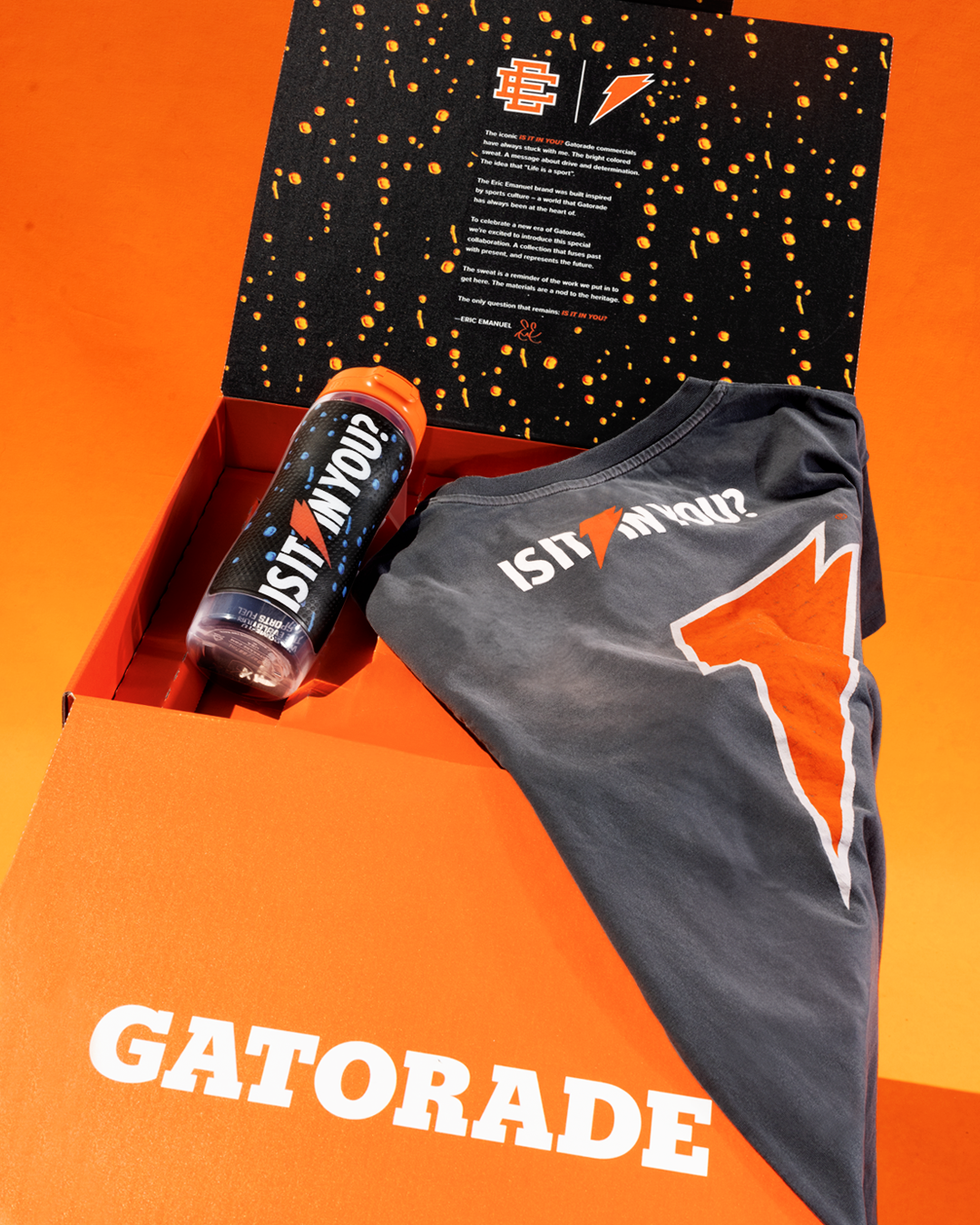 Gatorade-branded box containing a gray shirt with an orange logo and text &quot;IS IT IN YOU?&quot;, and a sports drink bottle with &quot;GROW FAST&quot; on the label