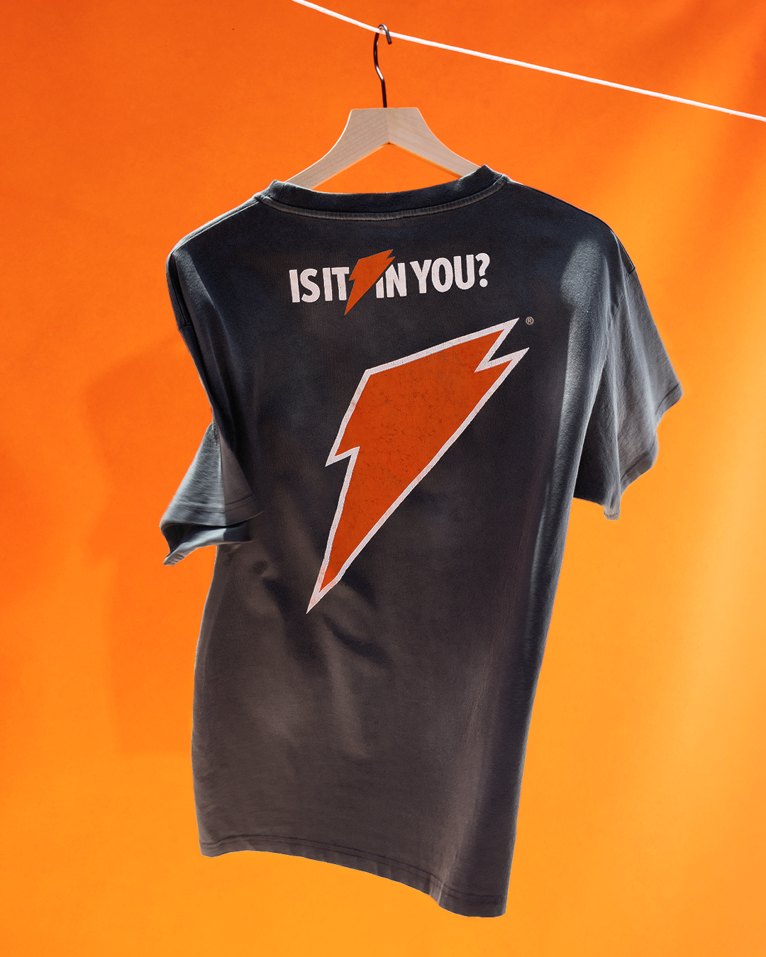 Black T-shirt on hanger with Gatorade logo and tagline &quot;Is it in you?&quot; on an orange background