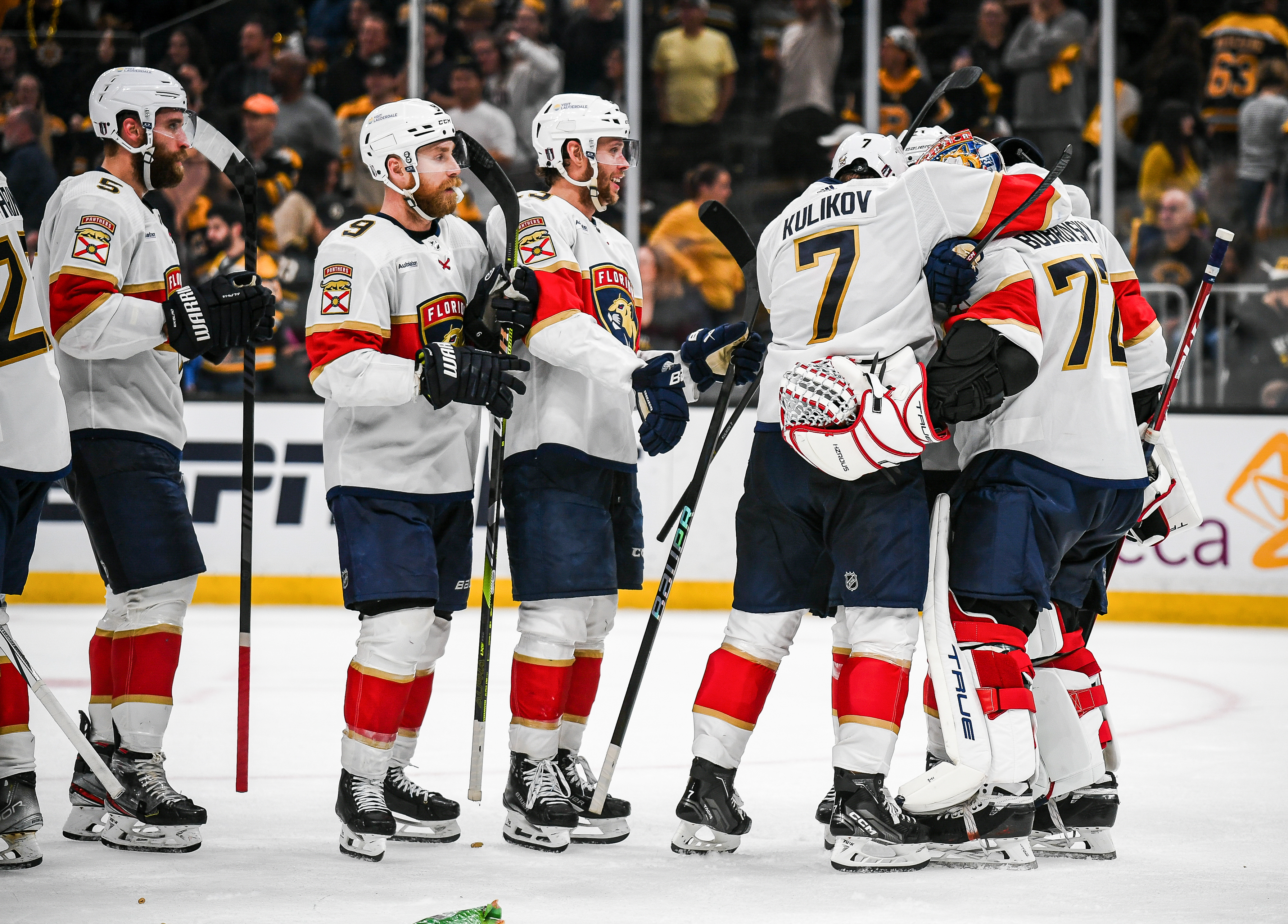 A group of hockey players from the Florida Panthers celebrate on the ice, including Sergey Bobrovsky, Dmitry Kulikov, and others