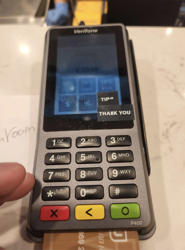 A credit card terminal displays a payment amount of $20.95. A finger hovers near the keypad with various tip percentage options visible on the screen