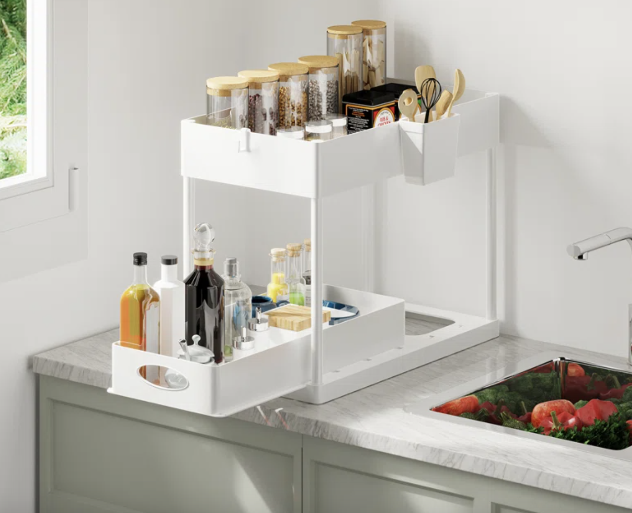 Kitchen counter with a white, multi-level organizer holding spice jars, bottles, and cooking utensils