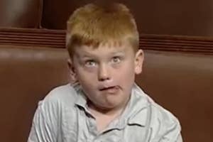 A young boy with red hair makes a funny face while looking slightly upward. This image is categorized as an Internet Find