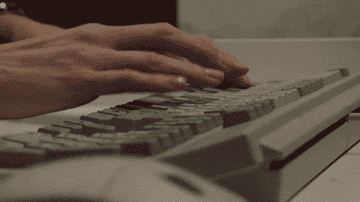 Hands typing quickly on a mechanical keyboard