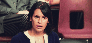 Lea Michele seated, looking confused or shocked in a classroom setting