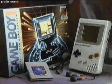 Vintage Nintendo Game Boy package including the console, box, game cartridge, link cable, headphones, and battery packs