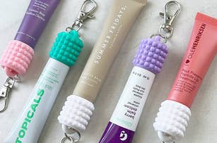 Laneige, Summer Fridays, Ole Henriksen lip products in tubes with keychain holders on a marble surface