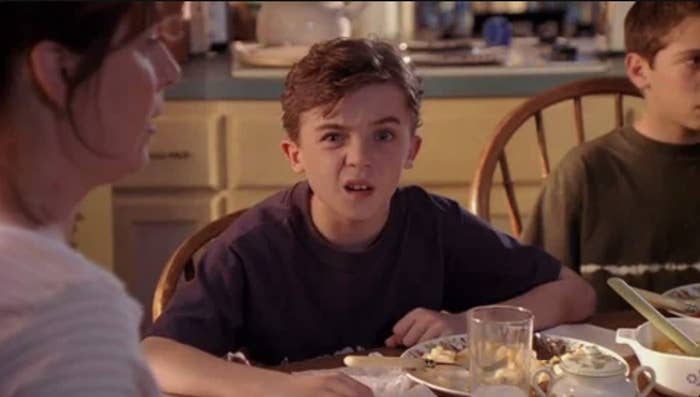 Frankie Muniz at a kitchen table, looking confused, from a scene in &quot;Malcolm in the Middle.&quot; Two other people are partially visible
