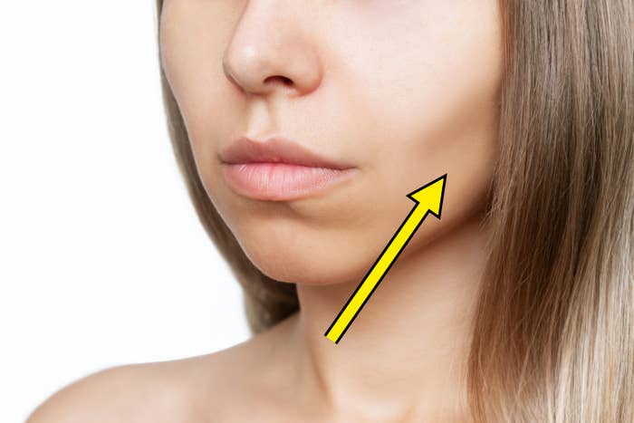 Close-up of a woman's lower face and neck with natural makeup, showcasing smooth skin. Her straight hair is visible along the side of her face