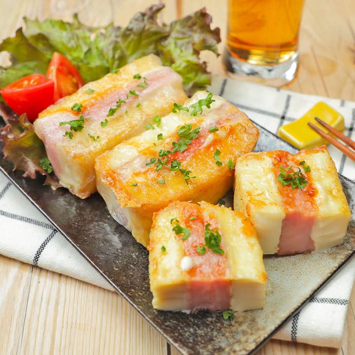 食事用プレートに並べられたベーコンとチーズを使った焼き料理とグラスに入った飲み物。
