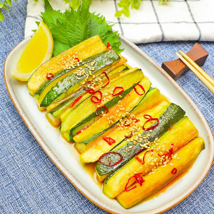 プレートに盛られたズッキーニの和え物、ゴマと刻んだ唐辛子がトッピングされています。