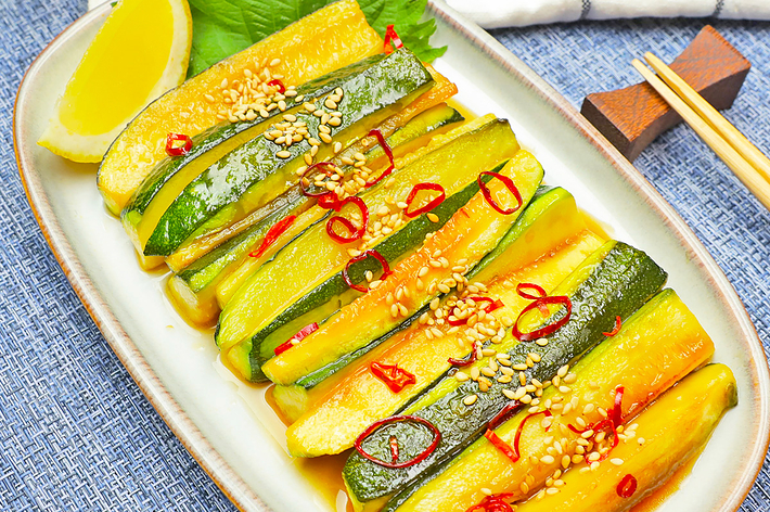 プレートに盛られたズッキーニの和え物、ゴマと刻んだ唐辛子がトッピングされています。