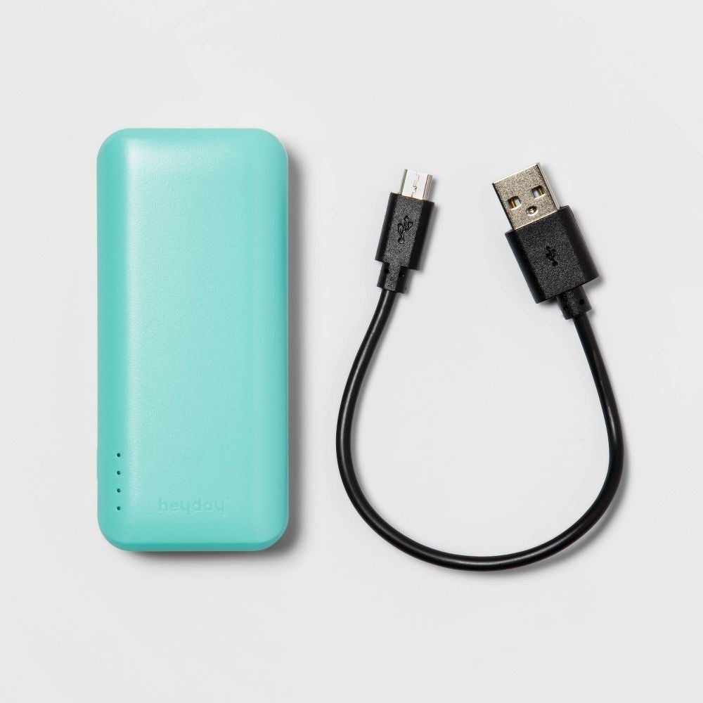 pengisi daya portabel teal dan kabel USB
