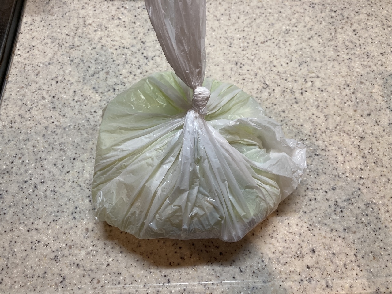 白いプラスチック袋に包まれ、縛られている物体が、カウンタートップの上に置かれています。