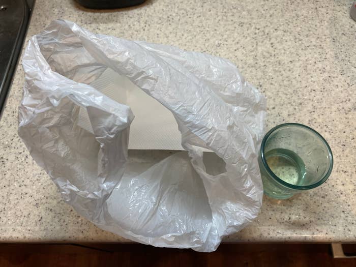 ビニール袋がカウンターの上にあり、その横にガラスのコップが置かれています。