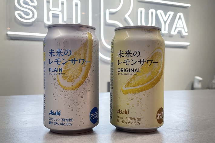 浅木の「未来のレモンサワー」2種類の缶が並んでいる。左はプレーン、右はオリジナル。배경には「SHIBUYA」のサインが光っている。