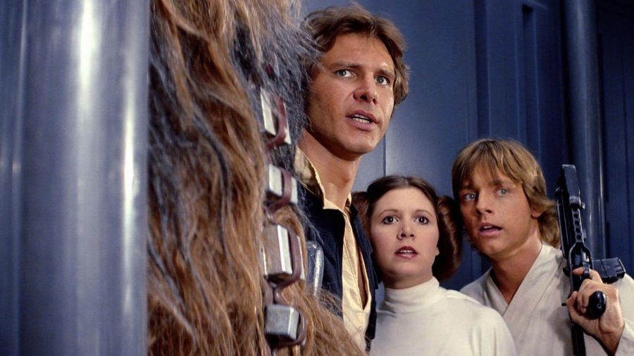 Chewbacca, Harrison Ford as Han Solo, Carrie Fisher as Princess Leia, and Mark Hamill as Luke Skywalker in a tense scene from Star Wars