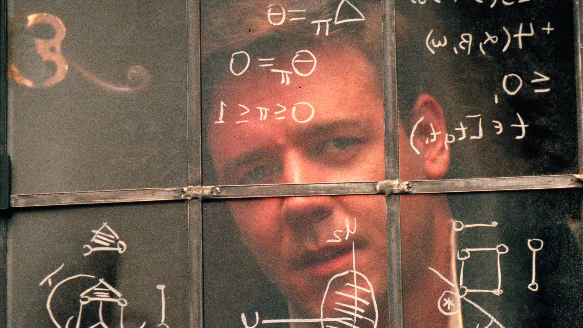 Russell Crowe peers through a window covered in mathematical equations in a scene from "A Beautiful Mind."