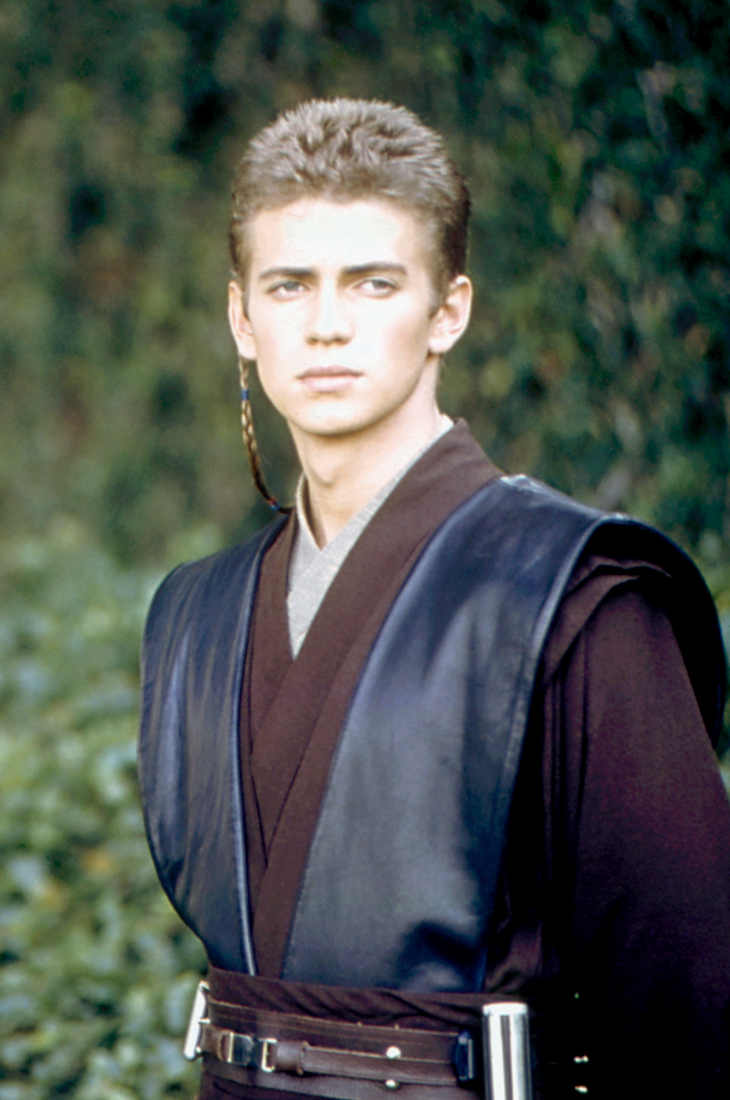 Hayden Christensen in a Jedi costume with a contemplative expression, against a natural background