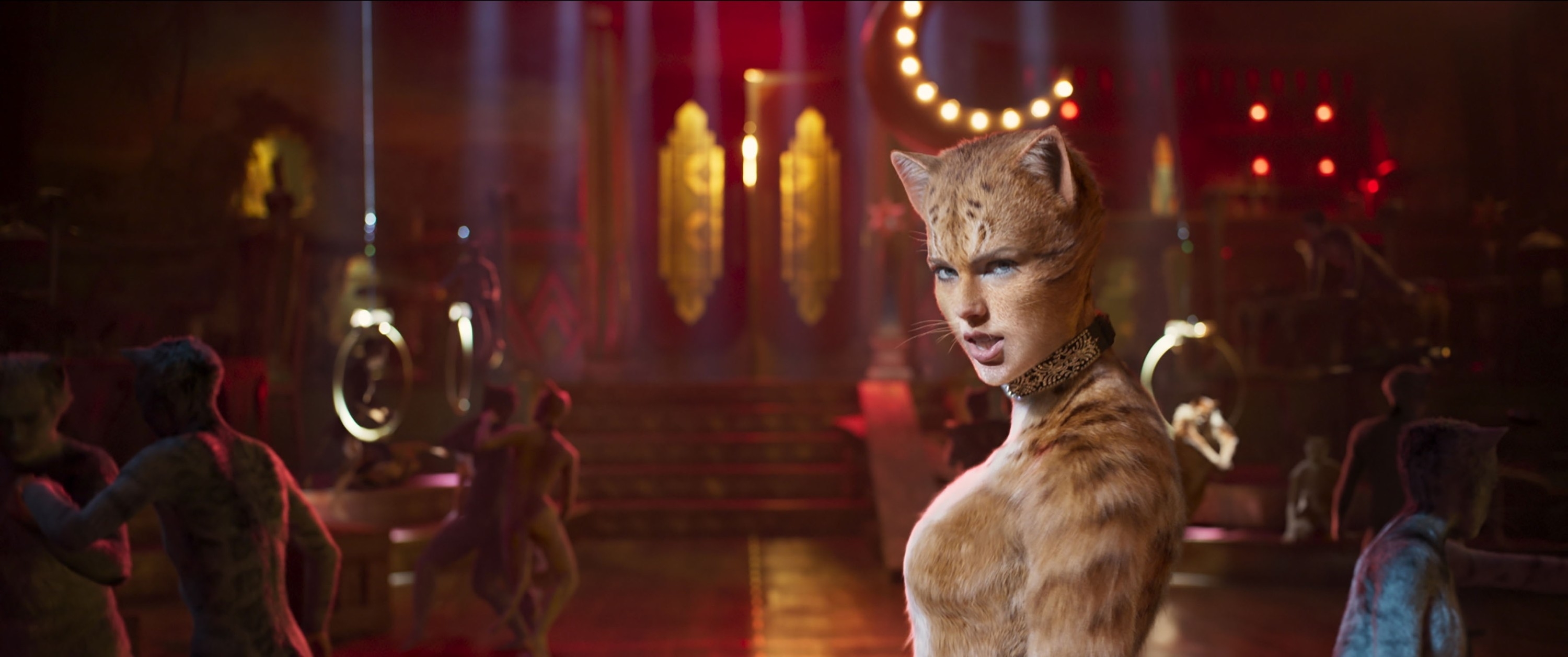 Taylor Swift as Bombalurina in a scene from the film &quot;Cats,&quot; wearing feline makeup and costume, set in a theatrical, dimly lit venue