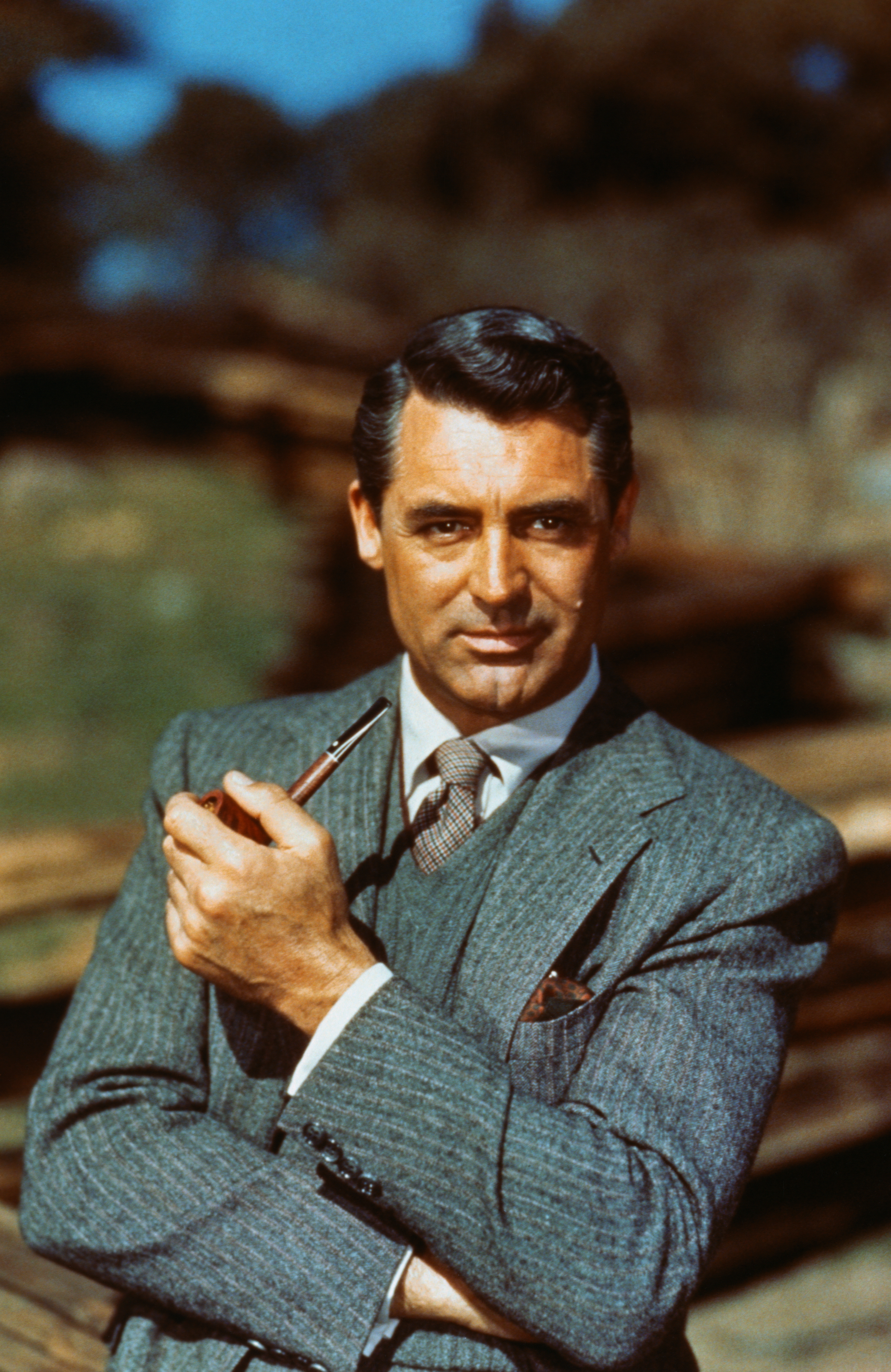 Cary Grant holding a pipe, wearing a classic suit