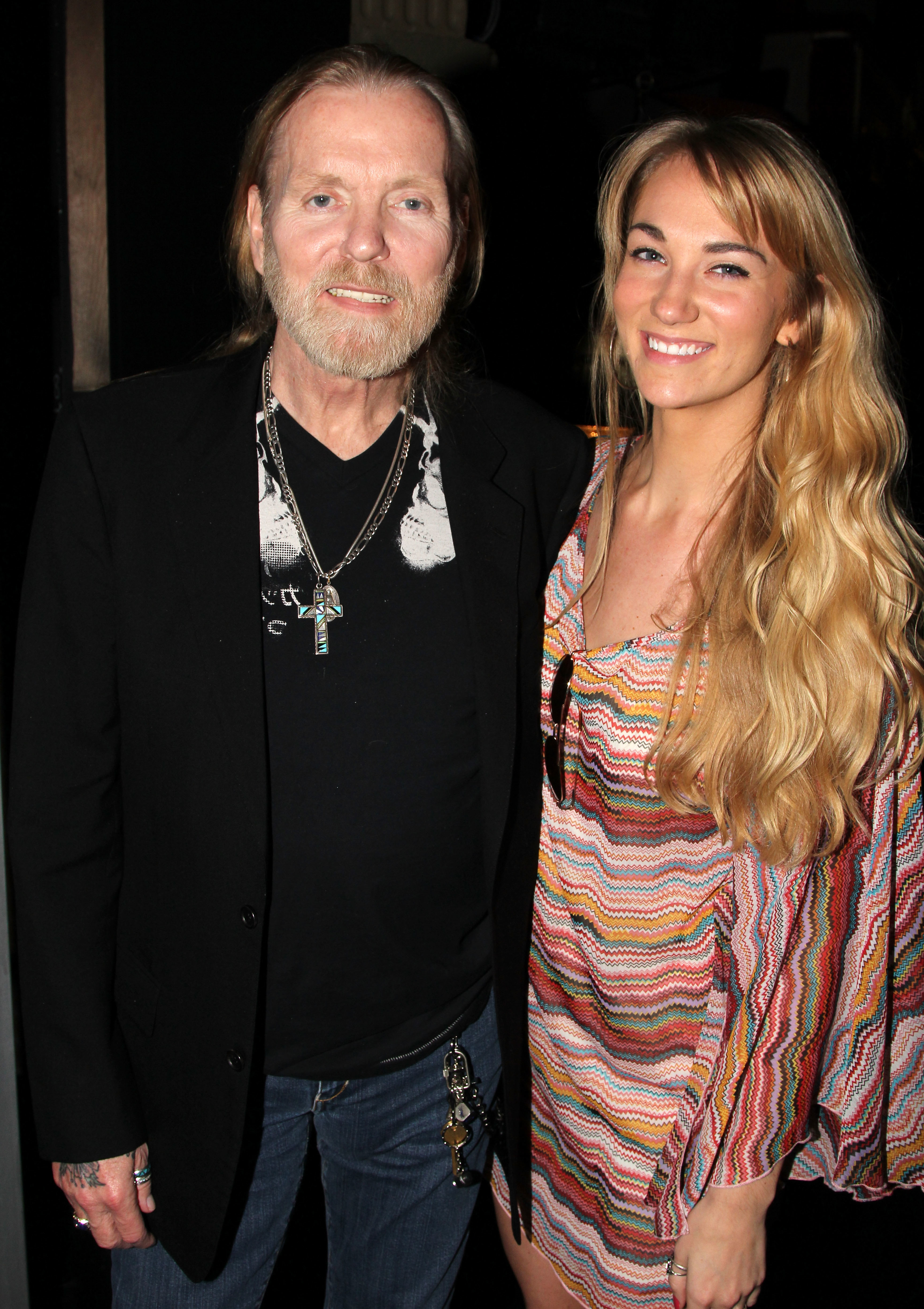 Gregg Allman in a black blazer and t-shirt, and Shannon Williams in a patterned dress, smiling for a photo