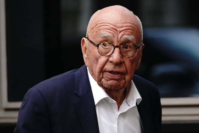 Rupert Murdoch in a white shirt and dark blazer, with a concerned expression