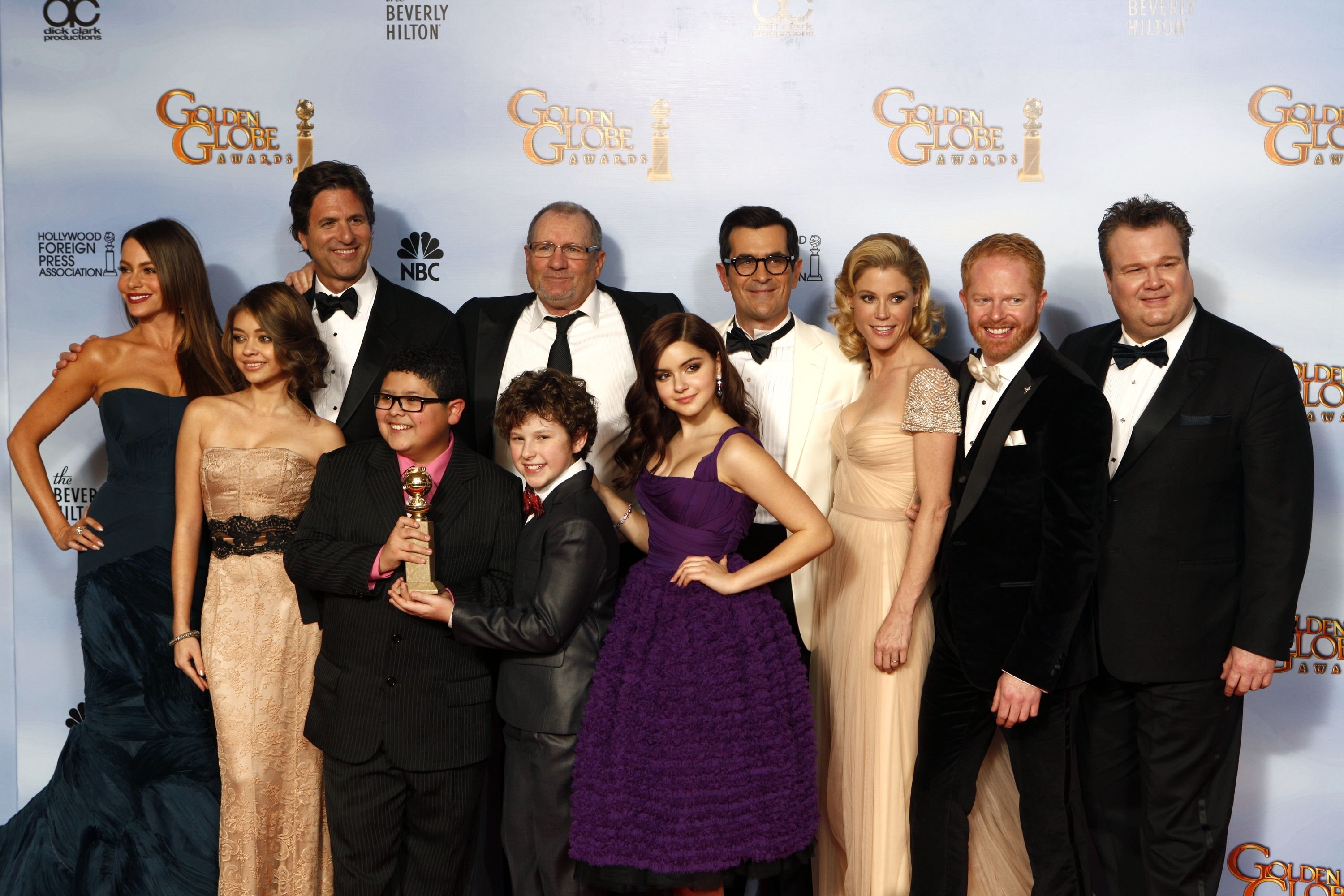 The cast of "Modern Family" posing at the Golden Globe Awards red carpet, dressed in formal attire