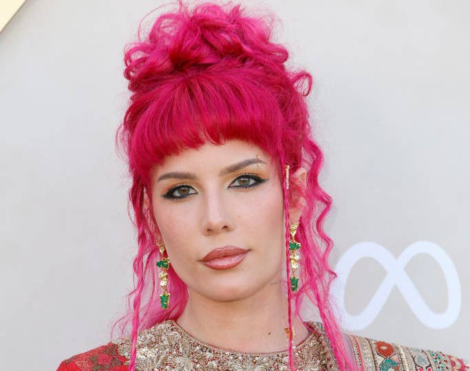 Halsey on the red carpet wearing a traditional outfit with intricate patterns and jewelry, featuring a cropped top and draped fabric