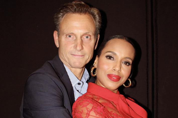 Tony Goldwyn and Kerry Washington pose together, with Tony in a suit and Kerry in an elegant lace dress. Both smile warmly at the camera