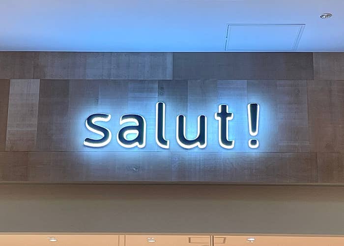 店の壁に「salut!」と書かれたネオンサイン。