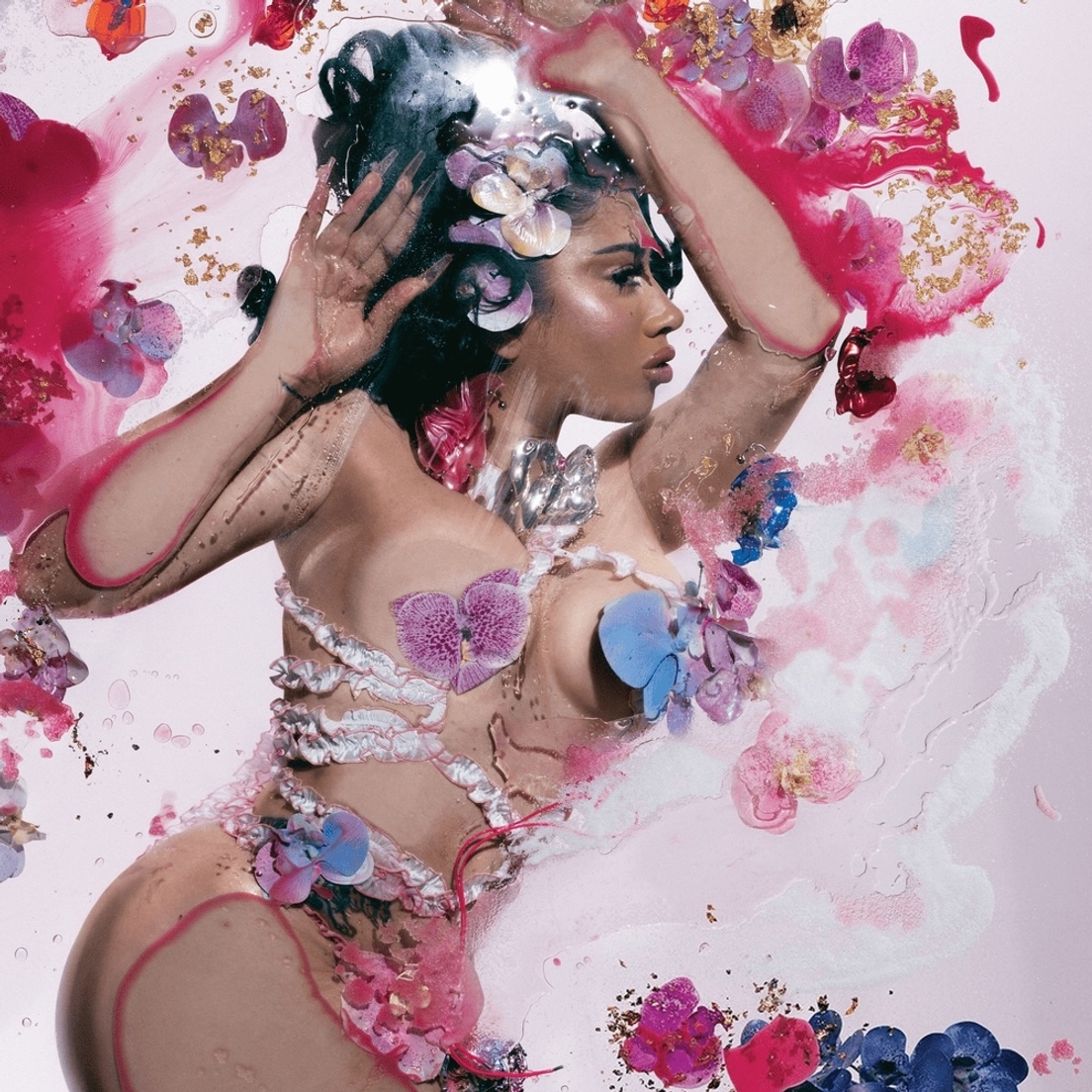 Nicki Minaj in a provocative outfit adorned with flowers in an artistic, abstract setting