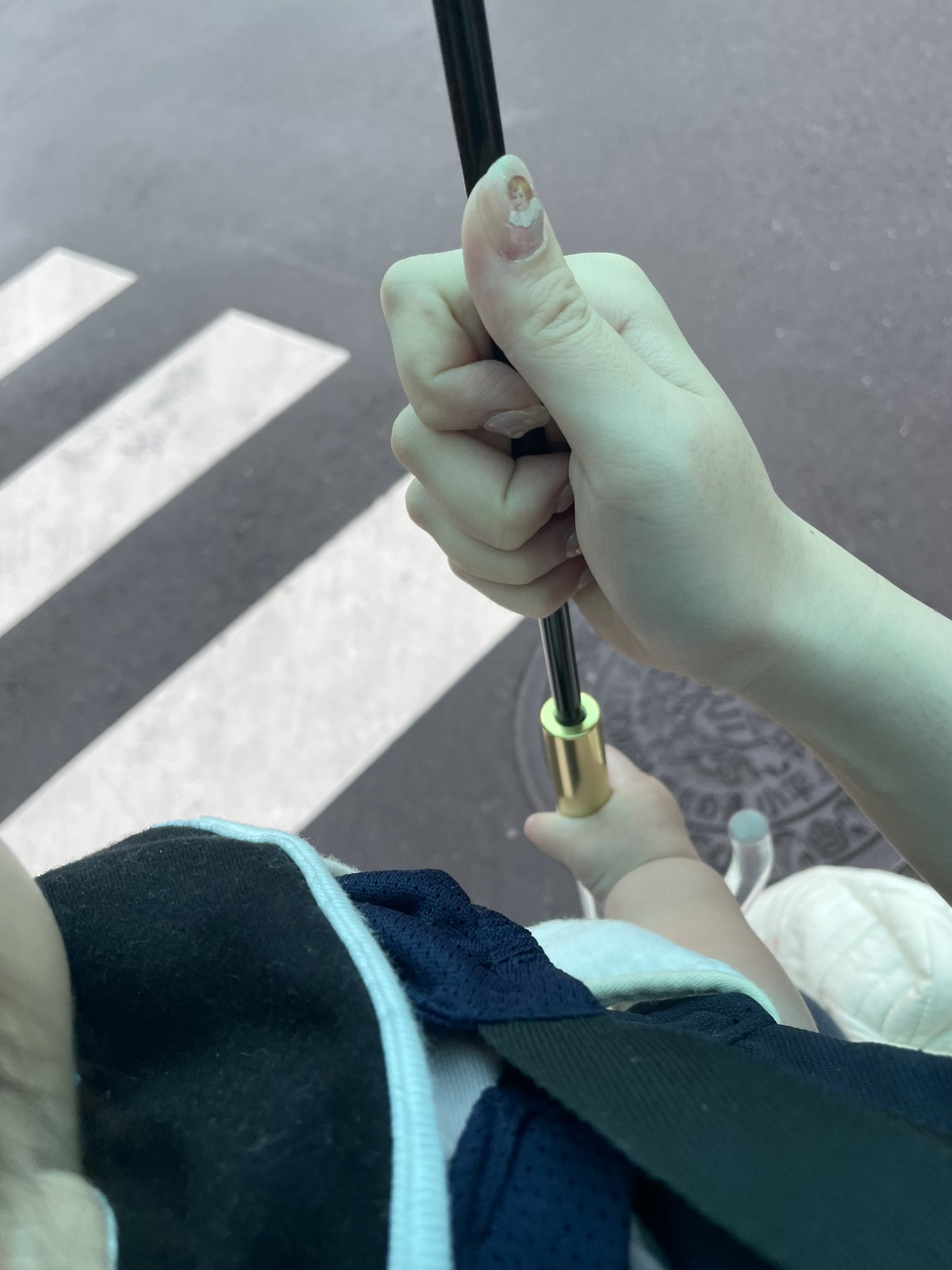 人物が傘を持って道路を渡る光景。この画像には有名人は写っていません。