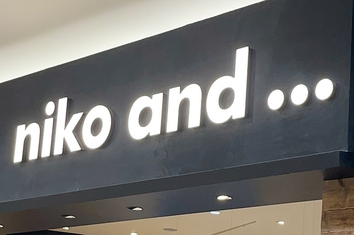Storefront of &ldquo;niko and &hellip;&rdquo; with various clothing and home goods displayed inside, located in a shopping mall
