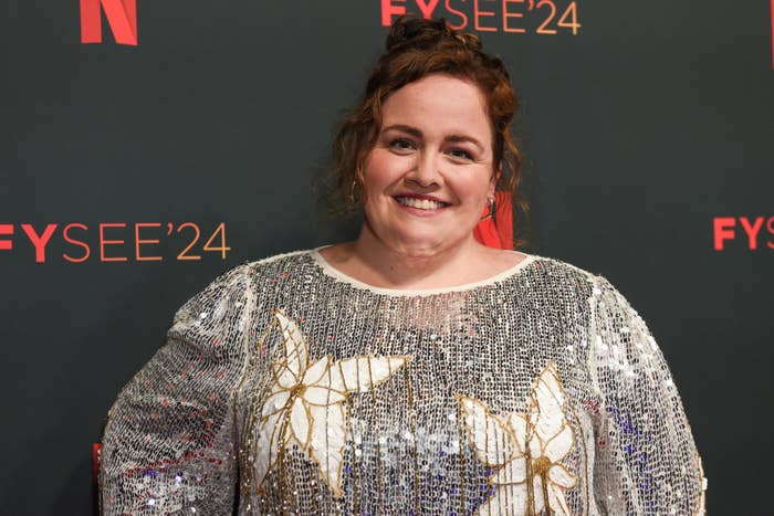 Jessica Gunning poses on the FYC 2024 red carpet in a sequined dress with floral patterns, smiling