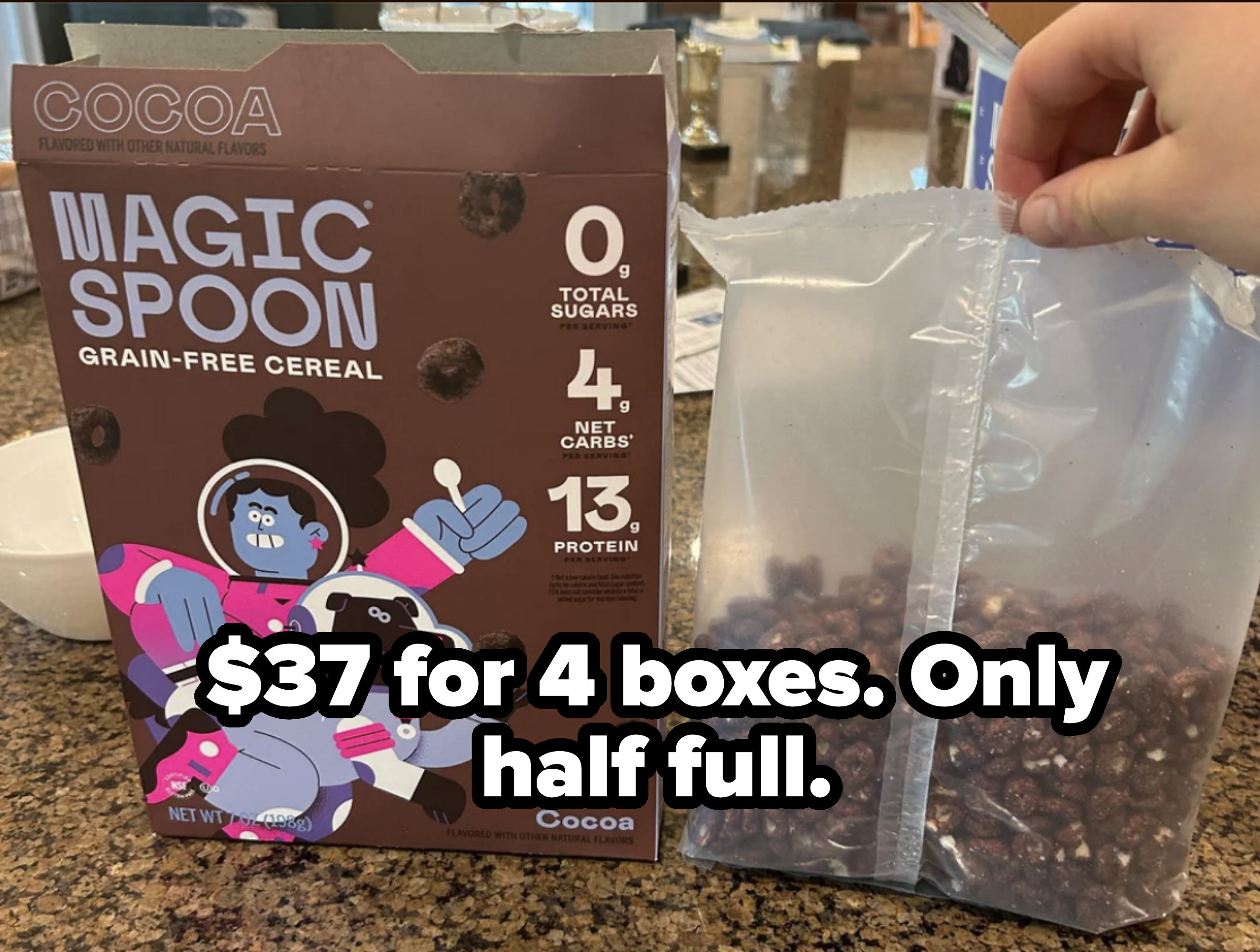 A hand holding an opened bag of Magic Spoon Cocoa Grain-Free Cereal next to the cereal box. The box highlights it has 0g sugars, 4g net carbs, and 13g protein