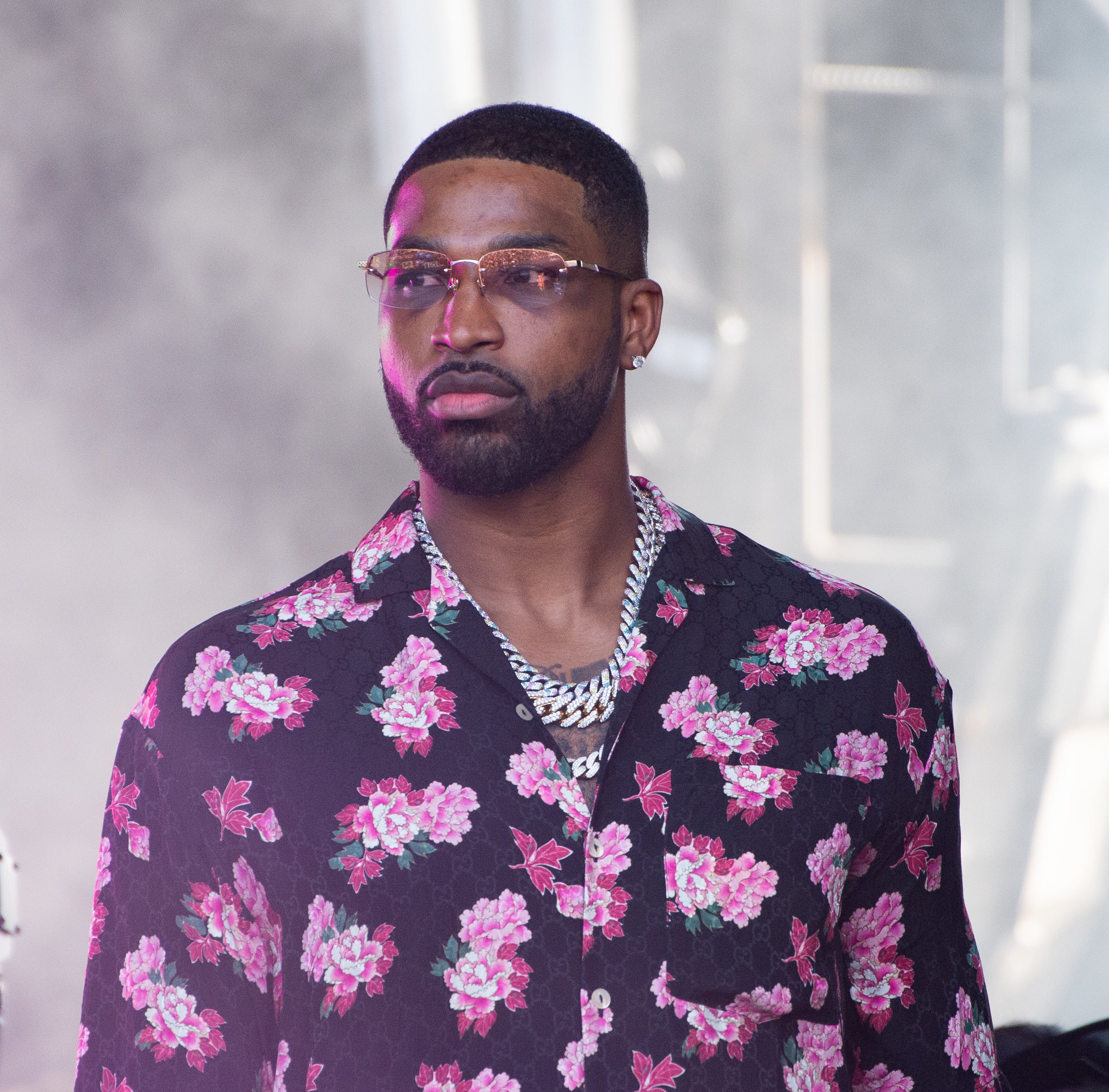 Tristan Thompson is wearing a floral patterned shirt and a silver chain necklace