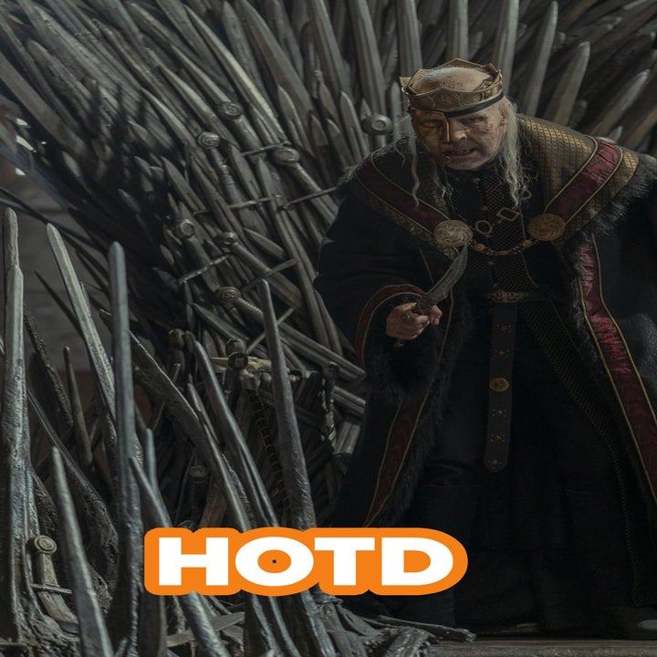 Viserys I Targaryen dressed in royal attire with a crown, stands poised, surrounded by the Iron Throne's sharp swords in a scene from House of the Dragon