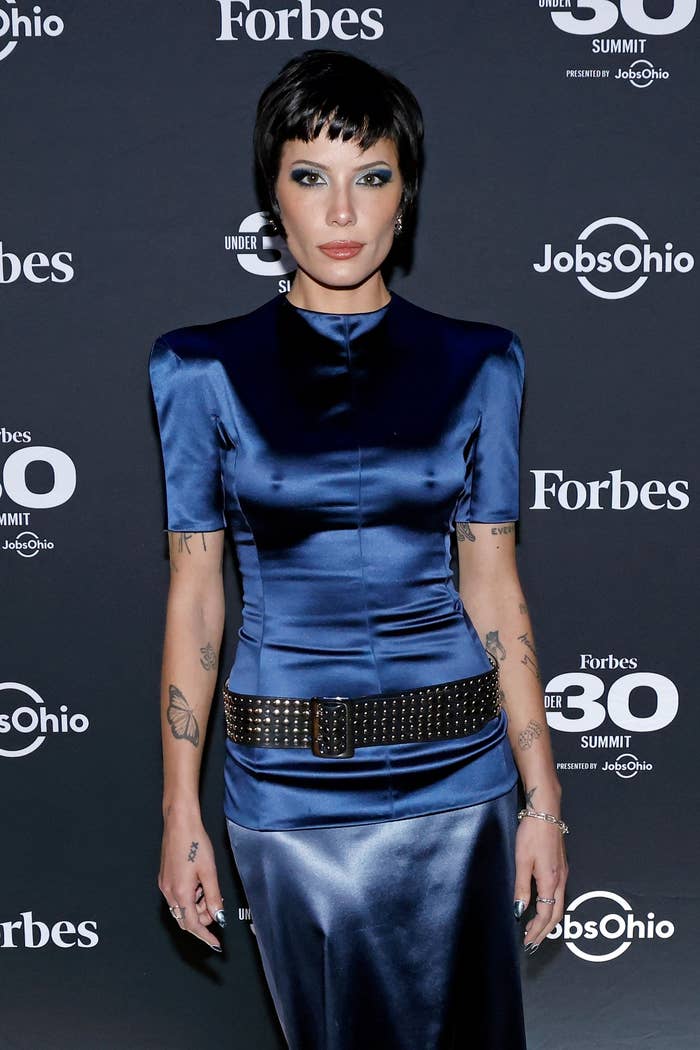 Halsey at the Forbes Under 30 Summit wearing a sleek, form-fitting dress with a studded belt