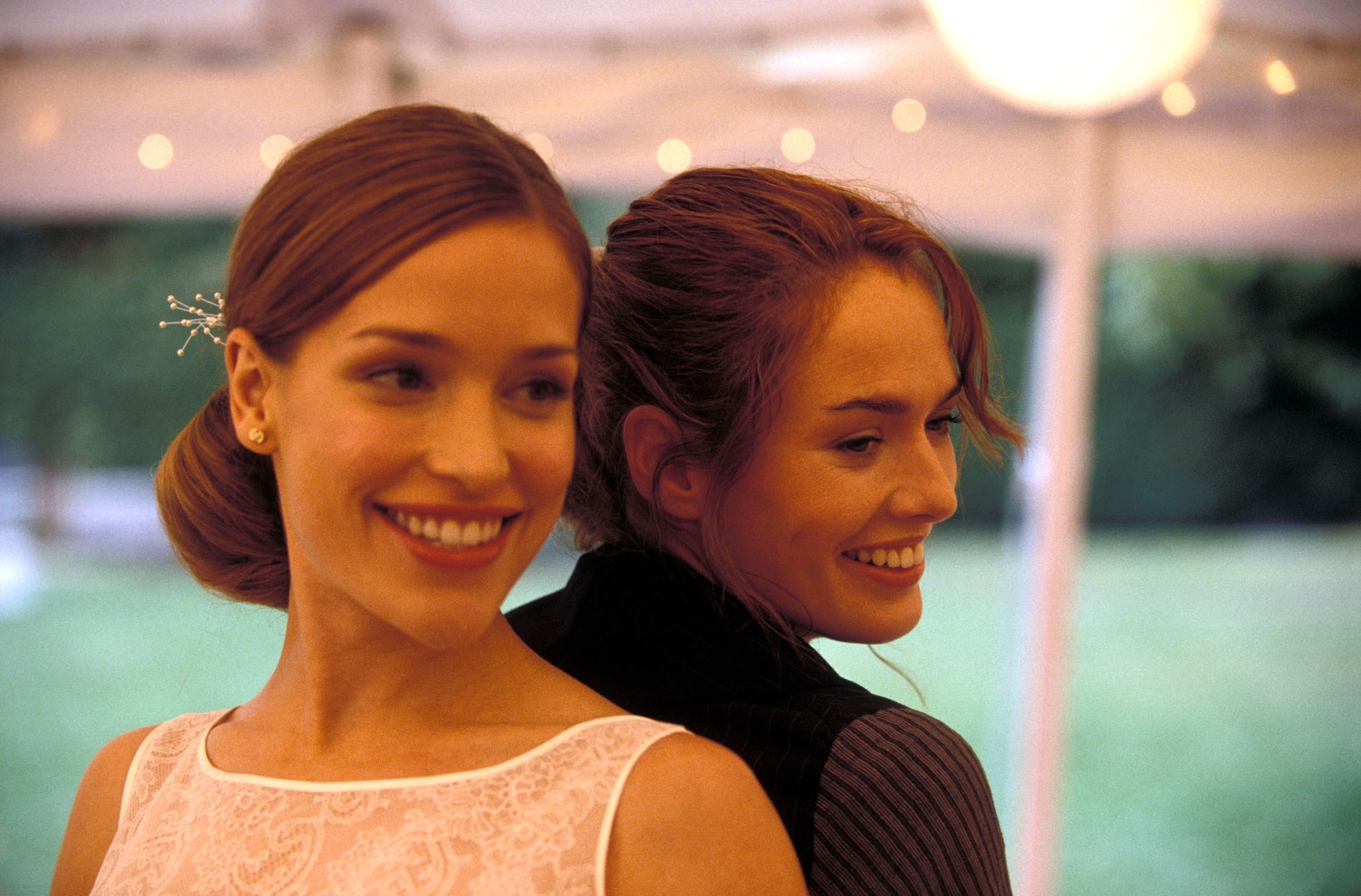 Piper Perabo and Lena Headey in a scene from the movie &quot;Imagine Me &amp;amp; You.&quot; The two actresses are standing back-to-back, smiling