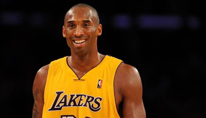 Kobe Bryant, wearing a Lakers jersey with the number 24, smiles on a basketball court during a game