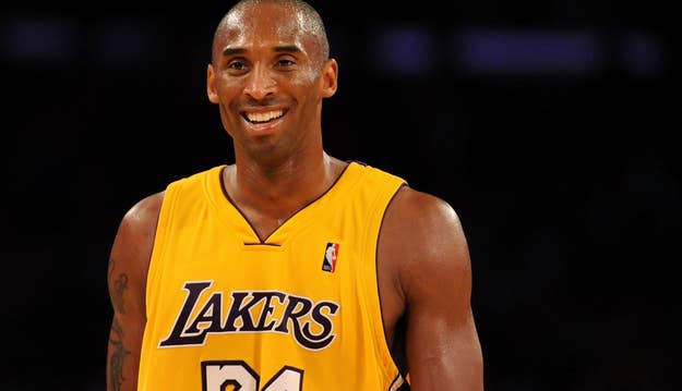 Kobe Bryant, wearing a Lakers jersey with the number 24, smiles on a basketball court during a game