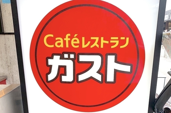 赤い円の中に「Caféレストラン ガスト」と書かれた看板。