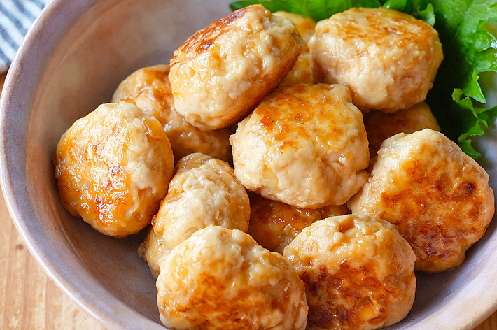 盛り付けられた照り焼きチキンつくねの料理。葉の装飾も添えられている。