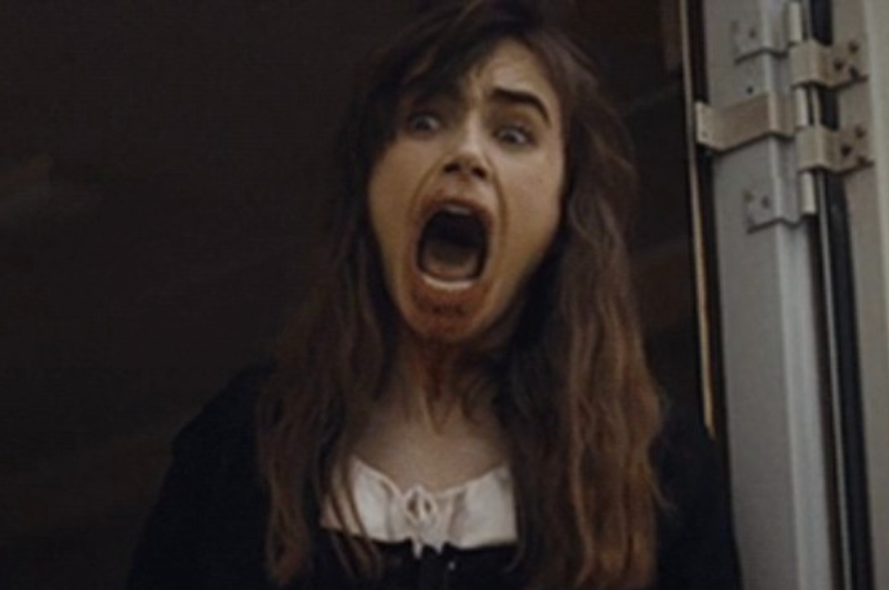Close-up of Lily Collins screaming with an open mouth, wearing a black and white outfit. Scene from a movie