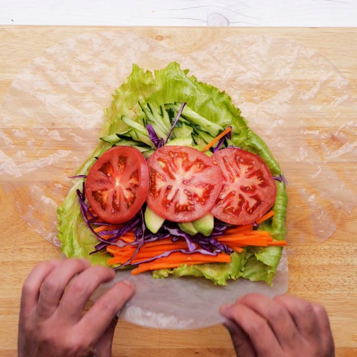 トマト、キュウリ、紫キャベツ、ニンジン、レタスがライスペーパーに包まれている様子。