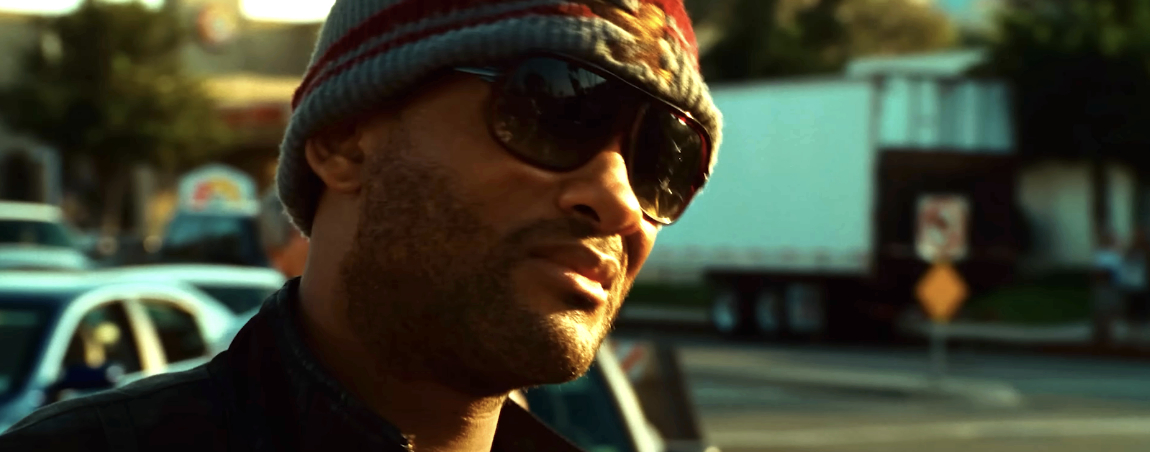 Will Smith wearing sunglasses and a beanie, standing outdoors in an urban setting