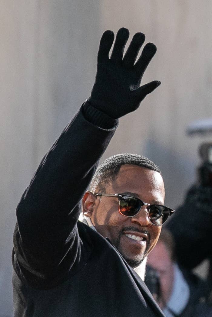 Martin Lawrence wears sunglasses and gloves as he waves and smiles